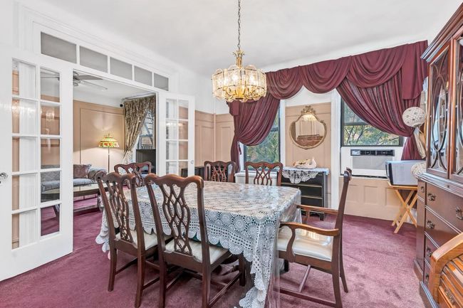 Dining space with carpet, a chandelier, french doors, and cooling unit | Image 12