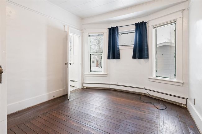 Empty room featuring dark hardwood / wood-style flooring and a baseboard heating unit | Image 8