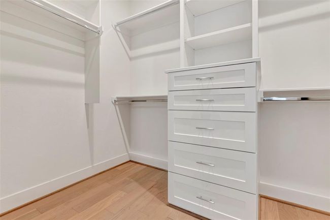 The primary bedroom boasts a spacious walk-in closet with plenty shelves & drawers. | Image 19