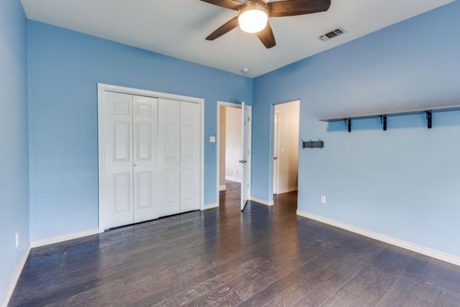 Unfurnished bedroom with baseboards, visible vents, wood finished floors, a closet, and ceiling fan | Image 25