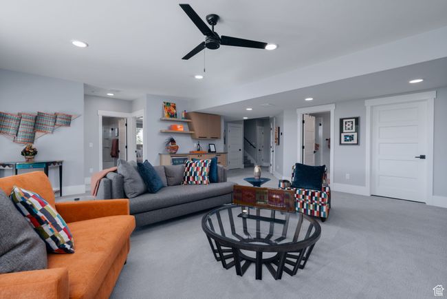 Living room with recessed lighting, light carpet, a ceiling fan, stairs, and baseboards | Image 29