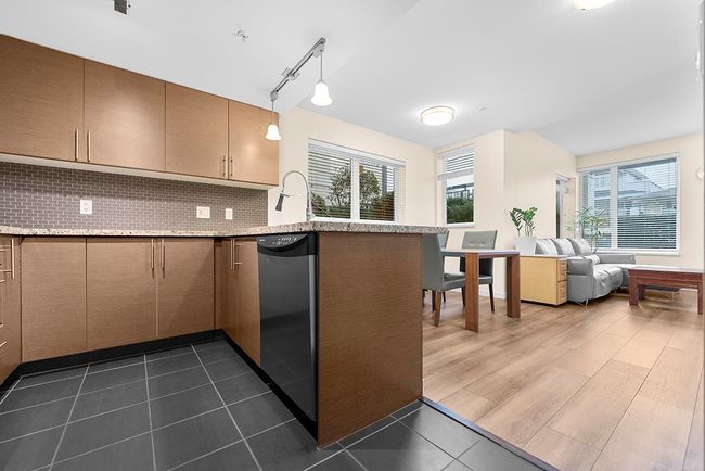 Kitchen with a wealth of natural light, dishwashing machine, open floor plan, and decorative backsplash | Image 10