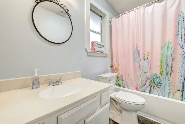 Full bathroom with vanity, toilet, shower / bath combo, and a textured ceiling | Image 20