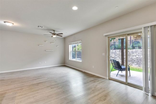 Natural colors, recess lighting, wall of windows and patio door makes the living space light and bright. Note the ceiling fan. | Image 7