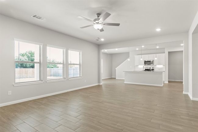 Unfurnished living room with a ceiling fan, recessed lighting, baseboards, and light wood-style flooring | Image 7