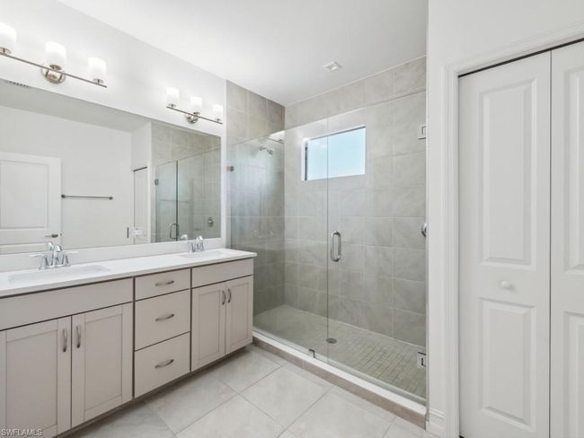 Bathroom featuring tile patterned flooring, vanity, and a shower with shower door | Image 19