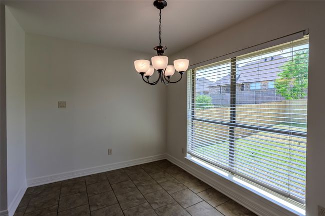 Spare room featuring plenty of natural light, baseboards, and an inviting chandelier | Image 19