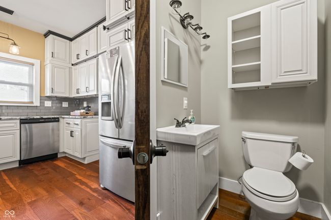 bathroom featuring vanity, tasteful backsplash, and dark wood-style floors | Image 22