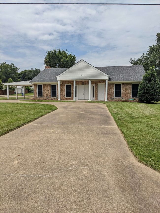 Single story home featuring roof with shingles, a front yard, driveway, and brick siding | Image 4