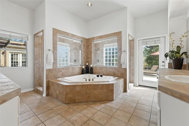 Full bath featuring vanity, tiled shower, a bath, and tile patterned flooring | Image 21