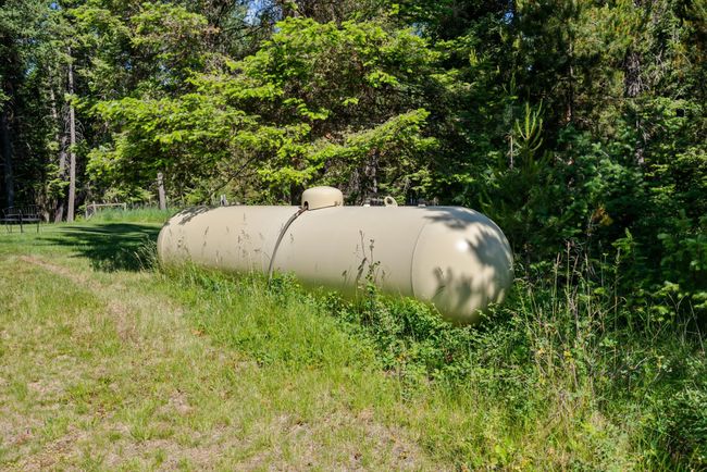 Exterior view of propane tank and a forest | Image 30