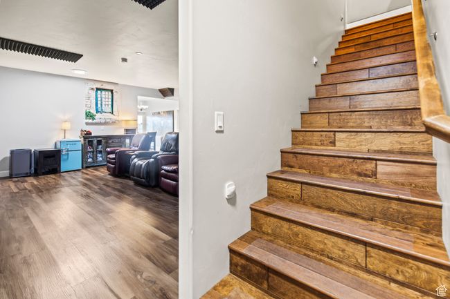 Stairs featuring wood-type flooring and indoor bar | Image 59
