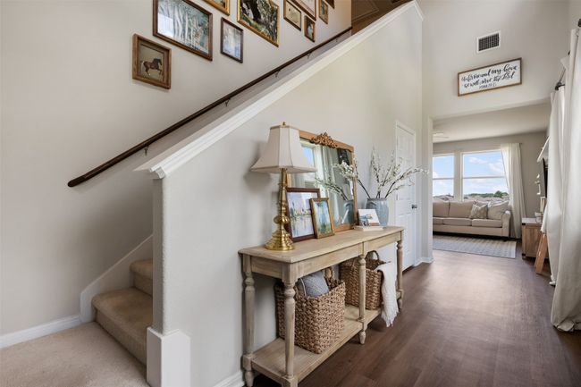 Stairway with baseboards, a towering ceiling, and luxury vinyl flooring. | Image 4