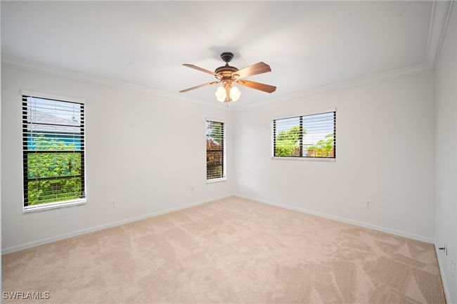 Spare room featuring ornamental molding, light colored carpet, and ceiling fan | Image 12