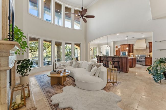 Living room and kitchen view with lots of windows that overlook the backyard patio and pool. | Image 8