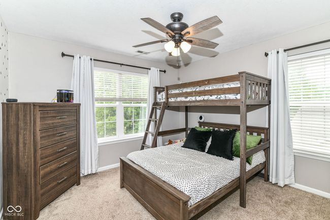bedroom with light colored carpet, baseboards, and ceiling fan | Image 19