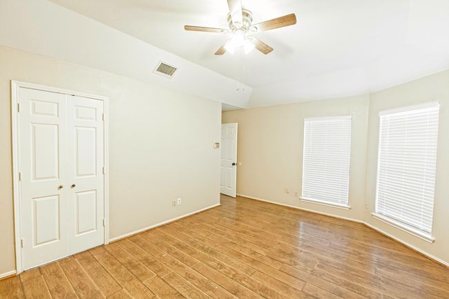 Unfurnished bedroom featuring light wood-type flooring, a closet, a ceiling fan, and vaulted ceiling | Image 20