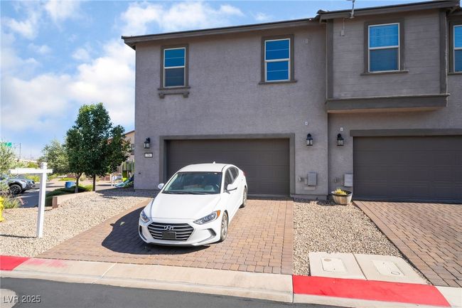 View of front of house with decorative driveway, stucco siding, and a garage | Image 39