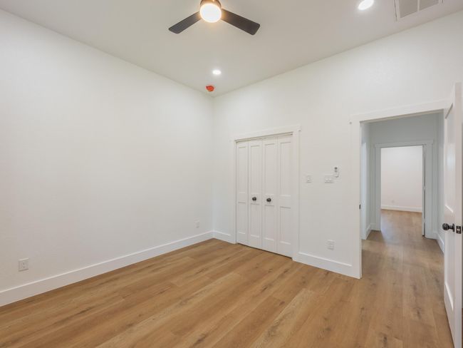 With large windows and recessed lighting, this secondary bedroom provides a peaceful atmosphere and plenty of space to personalize. | Image 34