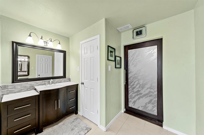 Bathroom featuring tasteful backsplash, visible vents, baseboards, tile patterned floors, and vanity | Image 18