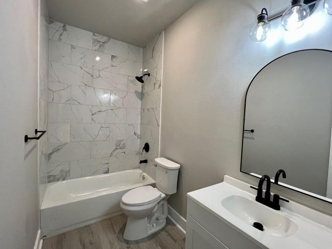 Full bath with wood finished floors, vanity, and washtub / shower combination | Image 22