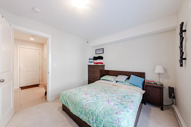 Bedroom featuring a baseboard radiator and light colored carpet | Image 28