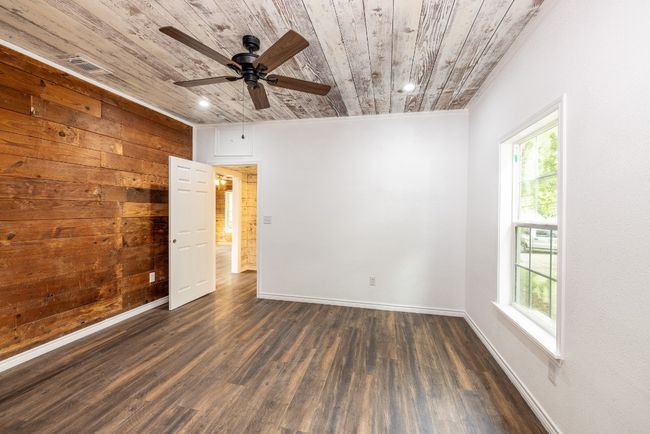 Unfurnished room featuring wood ceiling, a ceiling fan, and plenty of natural light | Image 12