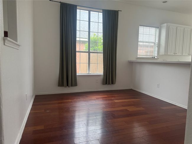Empty room featuring a healthy amount of sunlight, baseboards, and dark wood-style flooring | Image 6