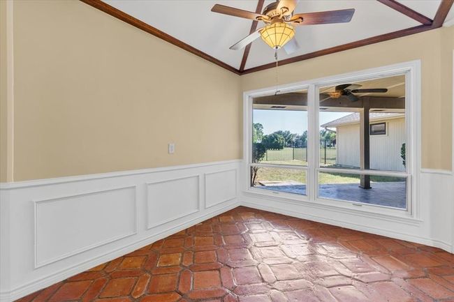 Spare room featuring lofted ceiling, ceiling fan, and crown molding | Image 15