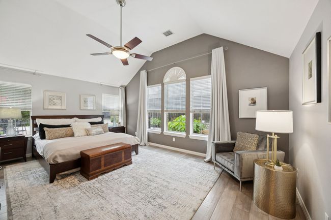 Vaulted ceilings, soft tones, and a wall of windows overlooking the pool create a relaxing escape in the spacious owner's suite—designed for rest and privacy. | Image 16