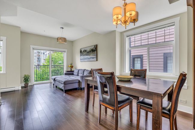 Dining area featuring a chandelier, dark wood-style flooring, baseboards, and a baseboard heating unit | Image 8