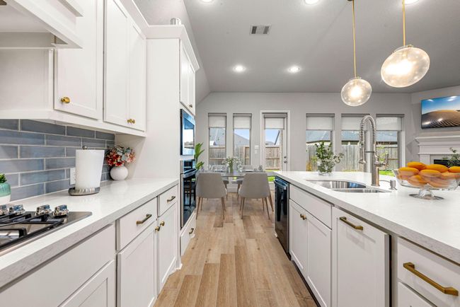 Any chef's dream, this stunning kitchen is perfect for everyday life as well as entertaining family and friends! Extra large kitchen island is perfect for conversation or that much needed space to lay out your party spread for everyone to enjoy! Large windows provide lovely views of your backyard and plenty of natural lighting throughout the day. *virtual staged* | Image 7
