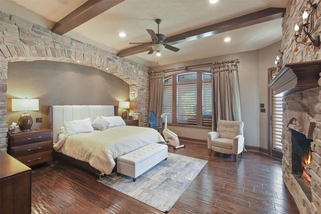 The primary bedroom has custom faux painting and wood beam ceilings | Image 24