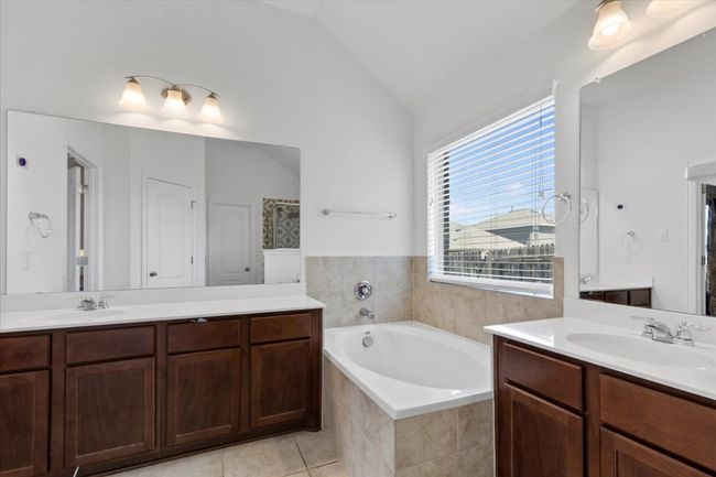 Full bath featuring a bath, two vanities, and a sink | Image 17