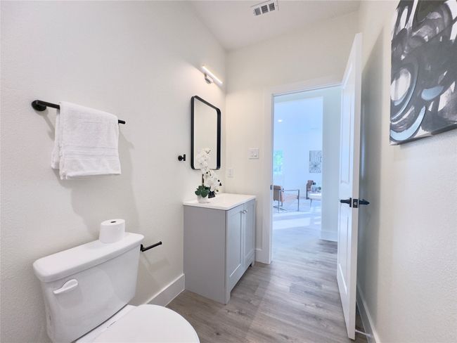 Bathroom with vanity, toilet, visible vents, baseboards, and wood finished floors | Image 11