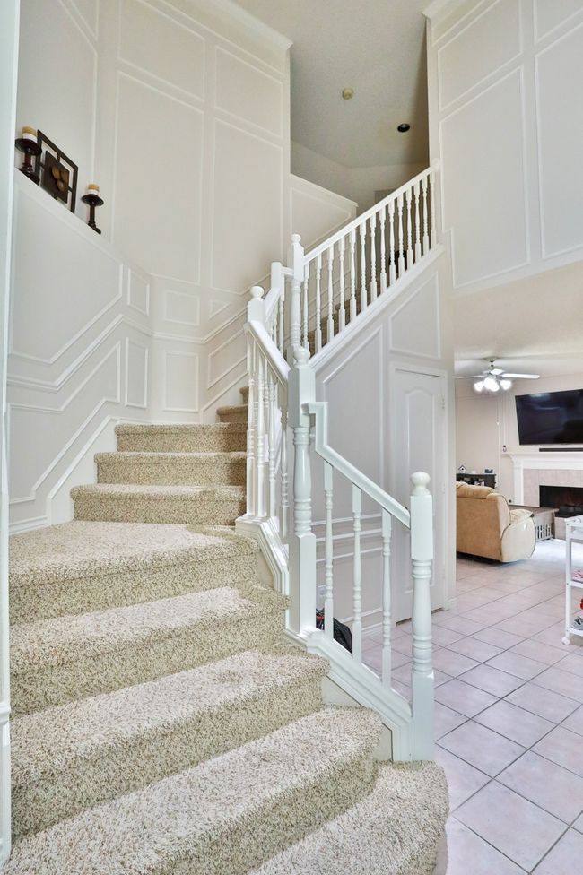 Stairway featuring a decorative wall, tile patterned floors, and ceiling fan | Image 15