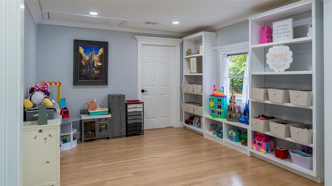 Recreation room with crown molding, wood finished floors, and recessed lighting | Image 15