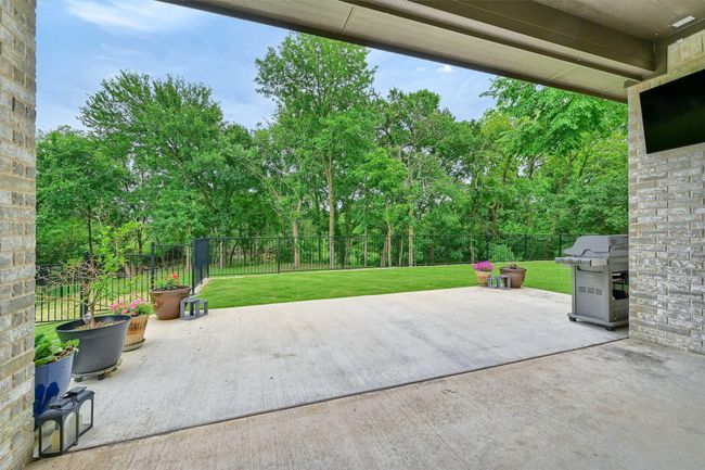 View of patio with a fenced backyard and a grill | Image 4