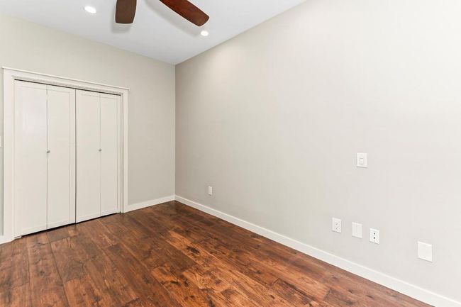 3rd bedroom with no window or study or bonus room with baseboards, dark wood-type flooring, recessed lighting, ceiling fan, and a closet | Image 25
