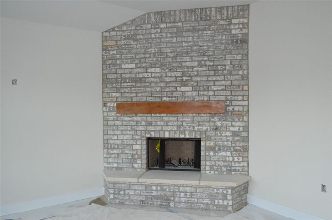 Detailed view of baseboards and a brick fireplace | Image 8