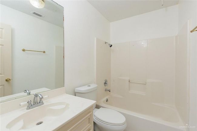 Full bathroom with vanity, toilet, tub / shower combination, and visible vents | Image 7