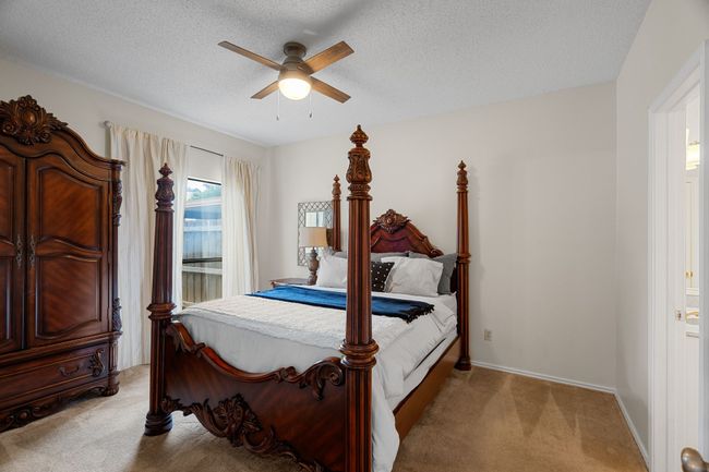 Bedroom featuring light carpet, a textured ceiling, and ceiling fan | Image 13