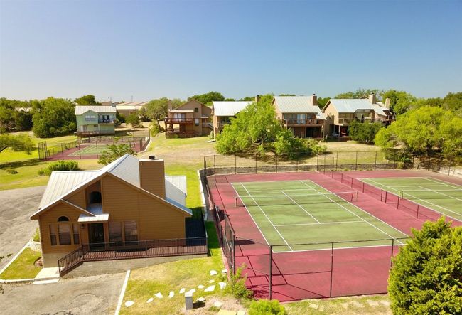 Side view showing that the home backs to one of the community tennis courts. | Image 4