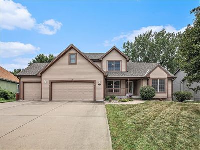 View of front of property with a garage, a front yard, and covered porch | Image 2