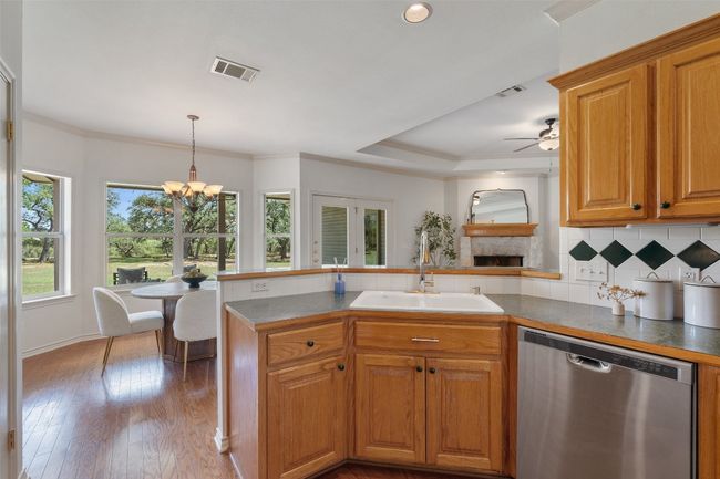 The kitchen is centrally located between the formal dining room and breakfast area, offering a breakfast bar. | Image 11