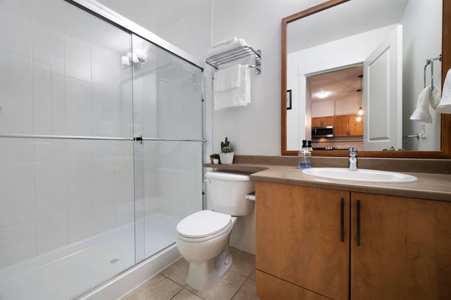Bathroom featuring a shower stall, tile patterned flooring, vanity, and toilet | Image 24
