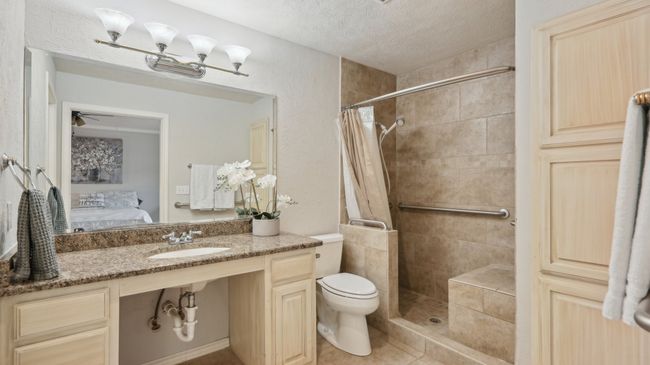 Full bath featuring a sink, connected bathroom, a shower stall, a textured ceiling, and toilet | Image 21