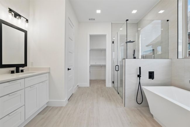 Full bathroom with vanity, a freestanding tub, a stall shower, visible vents, and wood finished floors | Image 31
