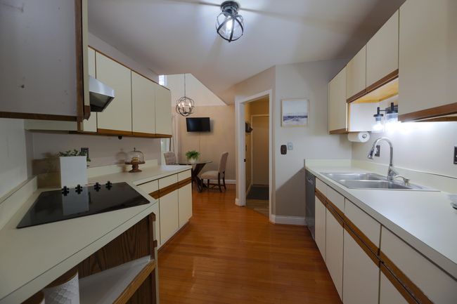 Large Galley kitchen with all appliances included. Hardwood floors and newer lighting. | Image 9