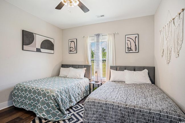 Bedroom with wood finished floors and ceiling fan | Image 21